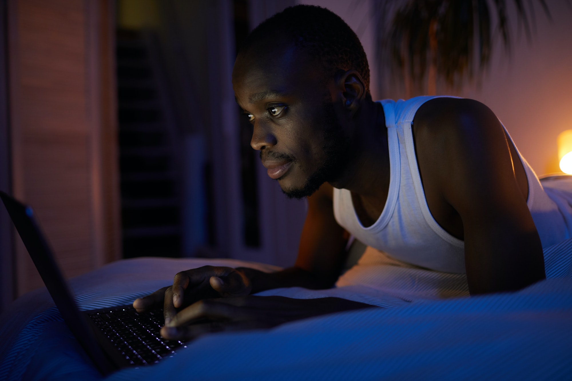 African Man Using Laptop at Night
